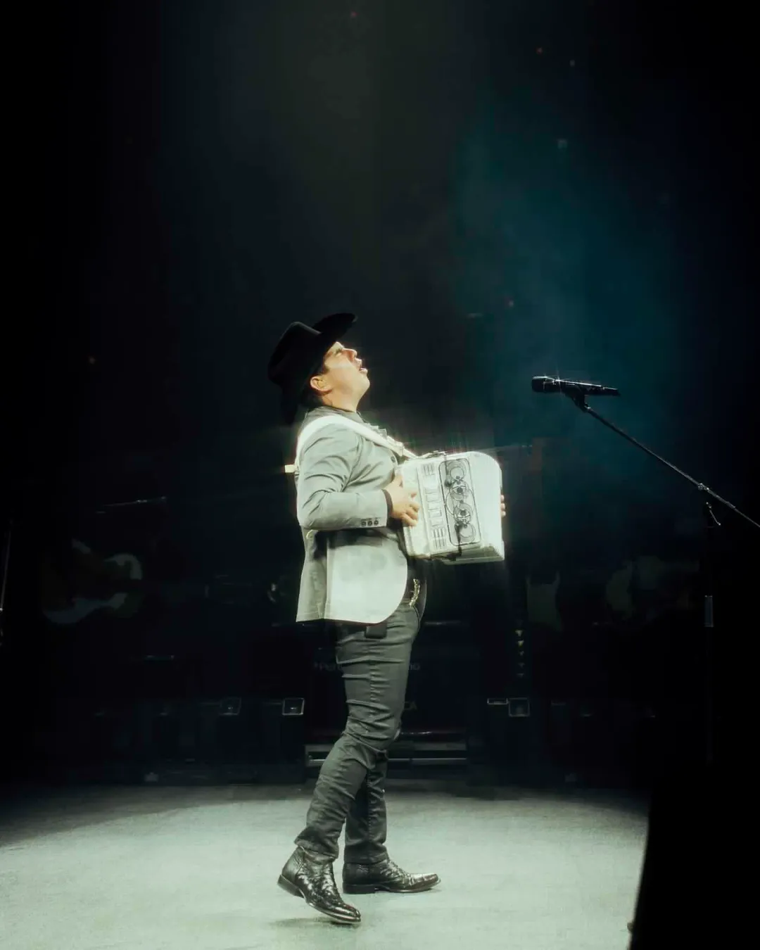 Alfredo Olivas con acordeón en el escenario del palenque